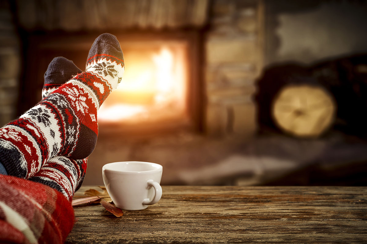 Warming feet by a fire at home