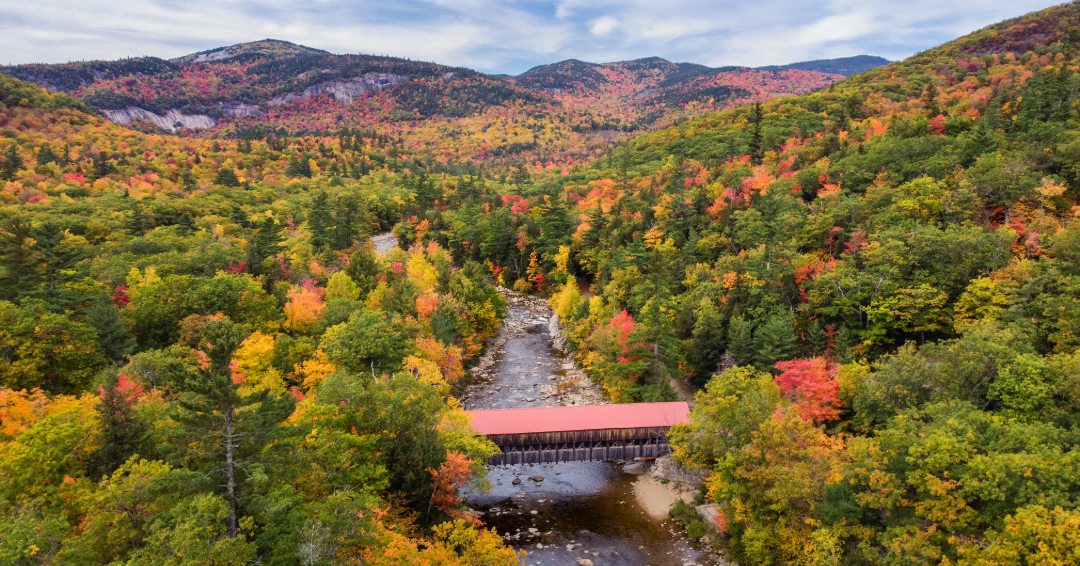 The Albany Covered Bridge along the Kancamagus Highway in New Hampshire’s White Mountains is surrounded by brilliant autumn foliage.