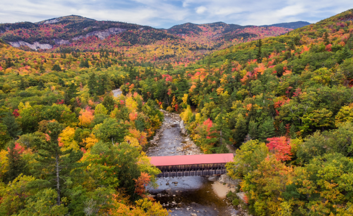 The Albany Covered Bridge along the Kancamagus Highway in New Hampshire’s White Mountains is surrounded by brilliant autumn foliage.