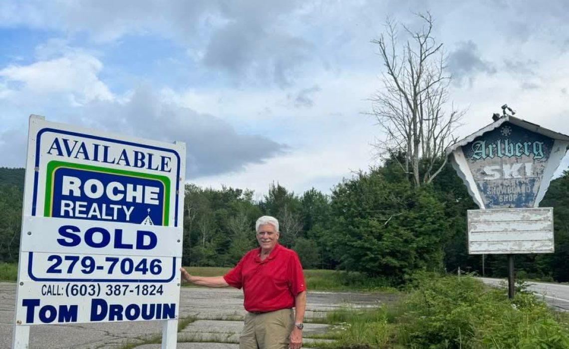 Tom Drouin with sold sign at the historic Arlberg Inn site